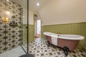 a bathroom with a bath tub and a shower at Hensill Farmhouse in Hawkhurst