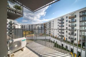 Cet appartement dispose d'un balcon offrant une vue sur les bâtiments. dans l'établissement ResiNest Apartamenty Kopernik, à Białystok