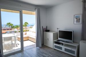 a living room with a television and a balcony at Lovely Sea View FREE WIFI in Adeje