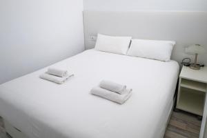 a white bed with two towels on top of it at Lovely Sea View FREE WIFI in Adeje +19 photos