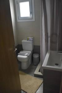 a bathroom with a toilet and a sink and a window at Garden House - Kastri Crete in Kastrí
