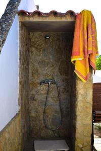 a shower in a stone wall with a towel at Casinhas da Figueira in Budens
