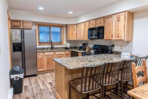 a kitchen with wooden cabinets and a granite counter top at Walk to Skiing Hiking and Main Street in Breckenridge