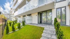 an exterior view of a house with a lawn at Apartamenty Magnet Jantaris in Mielno