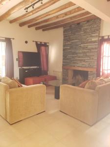 sala de estar con 2 sofás y chimenea en Casa Cálida Torrontés!! en Luján de Cuyo