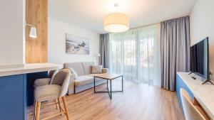 ミエルノにあるApartamenty Magnet Jantarisのソファとテレビのあるリビングルーム