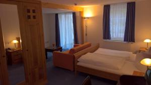 - une chambre avec un lit, un canapé et des fenêtres dans l'établissement CAREA Hotel Fürstenhof, à Haigerloch