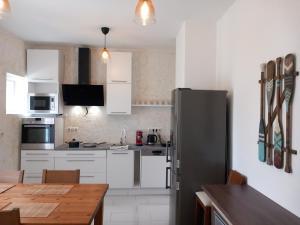 uma cozinha com armários brancos e um frigorífico de aço inoxidável em Korvin One Apartman em Pápa