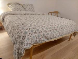 a bed with a gray and white blanket on it at Sweet place in Saint-Denis