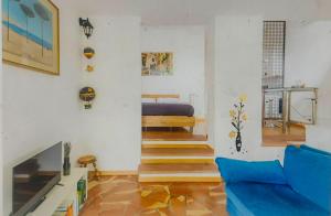 uma sala de estar com um sofá azul e uma cama em Casa Dei Leoni, luminoso open space immerso nel verde em Roma