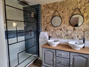 uma casa de banho com 2 lavatórios e uma cabina de duche em vidro. em Bon Chez Nous em Saint-Amand-Jartoudeix