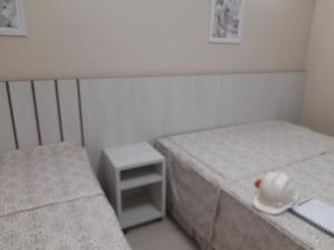 a room with two beds and a small table at SPAZZIO DiROMA HOTEL COM ACESSO AO ACQUA PARK in Caldas Novas