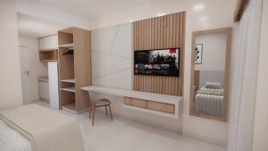 a bedroom with a desk and a bed and a mirror at SPAZZIO DiROMA HOTEL COM ACESSO AO ACQUA PARK in Caldas Novas