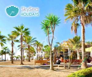 a group of palm trees in front of a resort at Sky Sea Holidays MIJAS COSTA in La Cala de Mijas