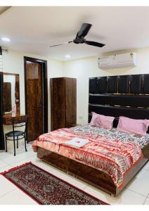 a bedroom with a large bed with a black headboard at THE RAJMANI MOTEL -- LUXURY STUDIO ROOMS -- LPU Law Gate in Phagwāra