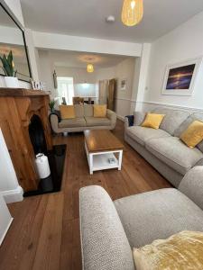 a living room with two couches and a table at Beach retreat! in Pakefield