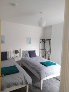a bedroom with two beds and two tables and a lamp at Beach retreat! in Pakefield