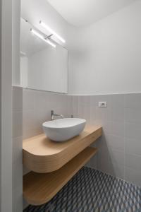 ein Badezimmer mit einem weißen Waschbecken auf einer Holztheke in der Unterkunft Giusà by DomuSicily in Palermo
