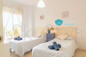 a bedroom with two beds with blue towels on them at Sky Sea Holidays MIJAS COSTA in La Cala de Mijas