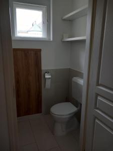 uma pequena casa de banho com um WC e uma janela em Korvin One Apartman em Pápa
