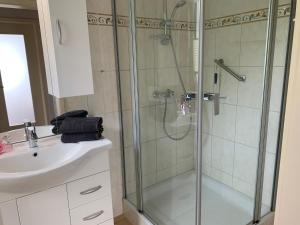 ein Bad mit einer Dusche und einem Waschbecken in der Unterkunft Ferienhaus Seeblick in Sassnitz