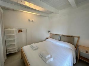 ein Schlafzimmer mit einem weißen Bett mit zwei Handtüchern darauf in der Unterkunft Maison Céline in Syrakus