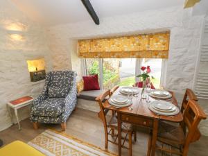 sala de estar con mesa, sillas y sofá en Primrose Cottage en Tenby