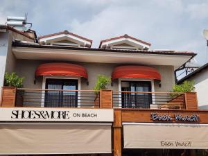 a house with a balcony with red awnings at Guney Suites by Villa Safiya in G&ouml;cek