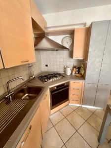 a kitchen with a sink and a stove top oven at Mè Cà - Appartamento vacanze in Riva del Garda