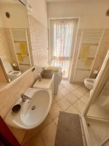 a bathroom with a sink and a toilet and a mirror at Mè Cà - Appartamento vacanze in Riva del Garda