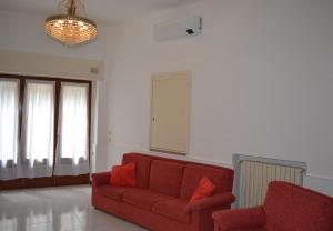 a living room with a red couch and a chandelier at L'Antico Borgo in Lesa