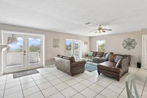 a living room with a couch and chairs and a ceiling fan at Sea Forever Ocean Lookout | Flagler Beach in Flagler Beach