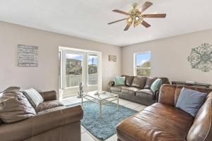 a living room with two couches and a ceiling fan at Sea Forever Ocean Lookout | Flagler Beach in Flagler Beach