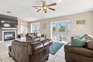 a living room with leather furniture and a ceiling fan at Sea Forever Ocean Lookout | Flagler Beach in Flagler Beach