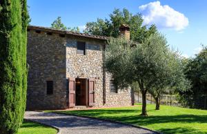 un bâtiment en pierre avec un arbre en face dans l'établissement Colto Dei Pallanti, à Cavriglia
