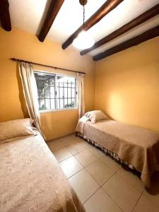 Een bed of bedden in een kamer bij LA CASITA DE ELENA, casa dos habitaciones totalmente equipada, centro de Lujan de Cuyo, MENDOZA