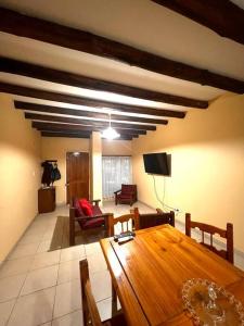 sala de estar con mesa de madera y TV en LA CASITA DE ELENA, casa dos habitaciones totalmente equipada, centro de Lujan de Cuyo, MENDOZA en Luján de Cuyo