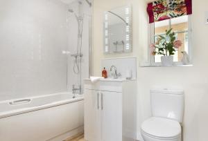 uma casa de banho branca com um WC, uma banheira e um lavatório. em Holywell House 4 Guests em Wellington