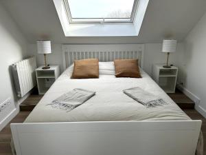 una camera da letto con un grande letto bianco con due comodini di Charmant appartement chez Pat a Caen