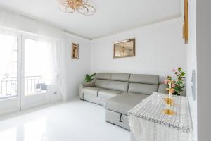 Una sala de estar blanca con un sofá y una mesa. en La Perle Bleue - Central - Vue Mer - Wifi, en Roquebrune-Cap-Martin