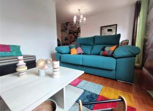 ein Wohnzimmer mit einem blauen Sofa und einem Tisch in der Unterkunft Coquetty Housing In Santander Bay in El Astillero