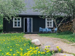 een zwart huis met twee stoelen en bloemen in de tuin bij Nightingale 