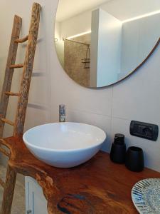 een badkamer met een witte wastafel op een houten tafel bij Picnic Room and Pool in Castelnuovo del Garda