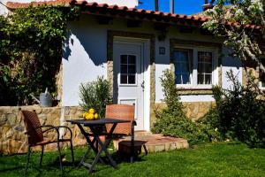 une table et des chaises devant une maison dans l'établissement Casinhas da Figueira, à Budens