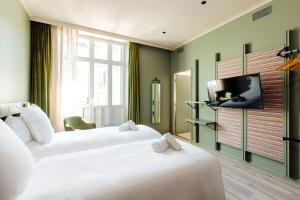 Televízia a/alebo spoločenská miestnosť v ubytovaní Hôtel Fernand - Entrée autonome, réception en ligne - Encore Mieux