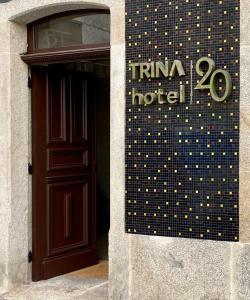 un panneau indiquant un hôtel à côté d'une porte dans l'établissement Hotel Trina 20, à Palas de Rei