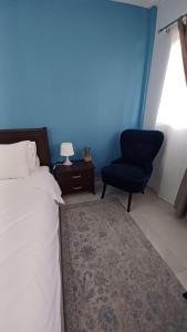 a bedroom with a bed and a blue wall at Blue Studio in Nea Moudania