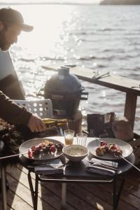 einen Tisch mit zwei Teller Essen auf einem Boot in der Unterkunft Yggdrasil Igloo Skåne in Höör