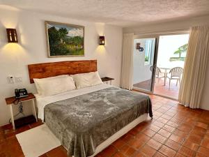 a bedroom with a large bed and a balcony at OceanBlue Resort in Christ Church