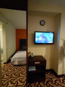 Habitación de hotel con cama y TV de pantalla plana. en Stay In Kay Kay Hotel Suite at South China Sea Place Suite en Kota Kinabalu